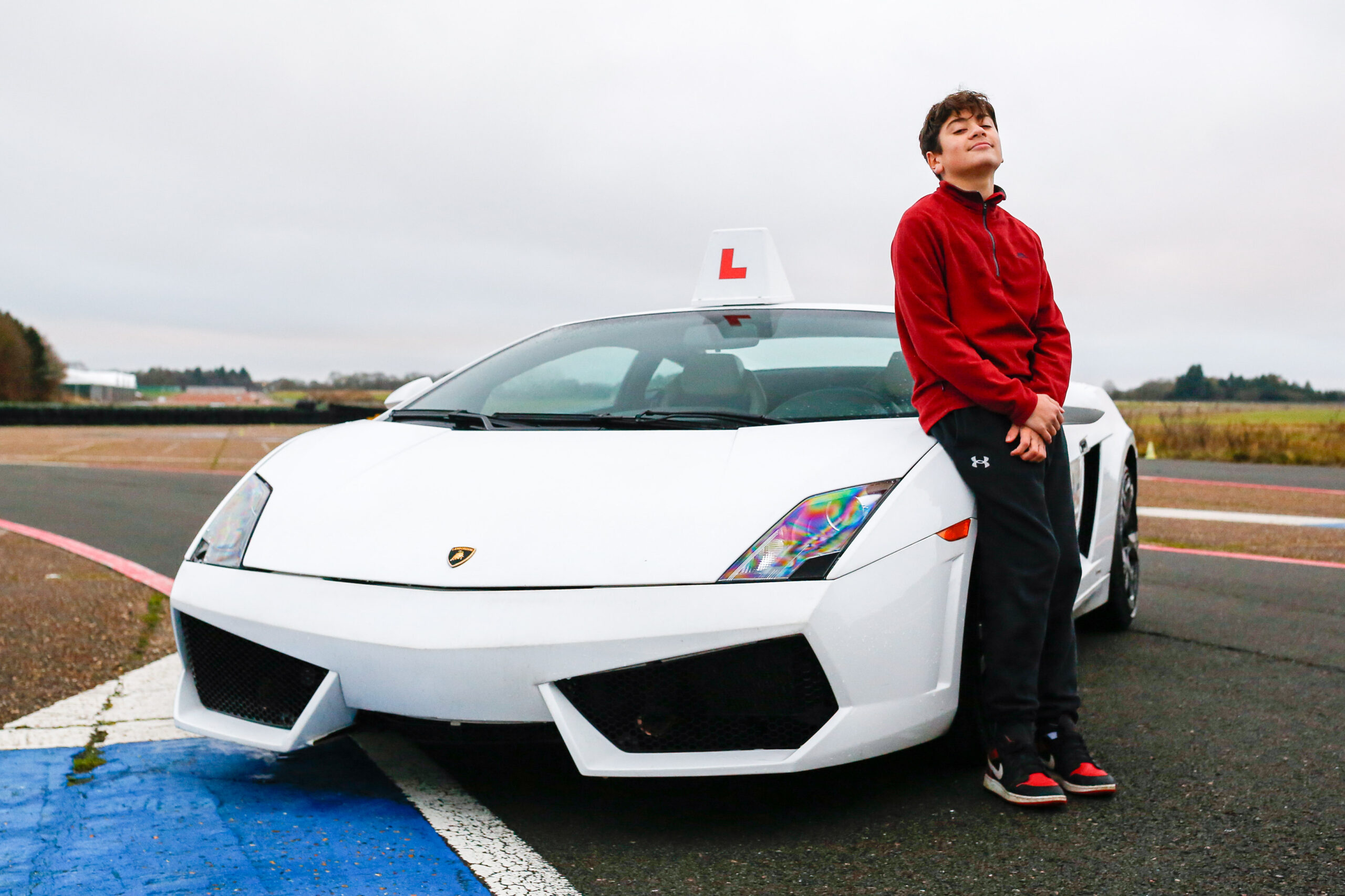 U17 SC-10 kid stood in front of a Lamborghini
